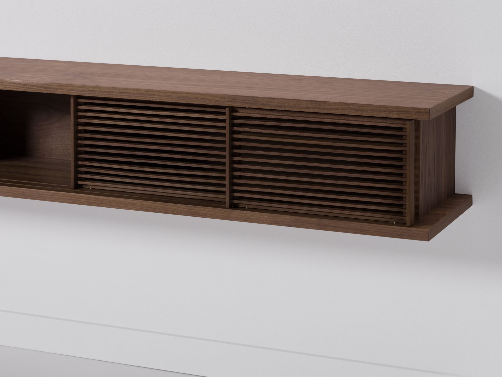 Large walnut floating media unit with slatted doors detail view